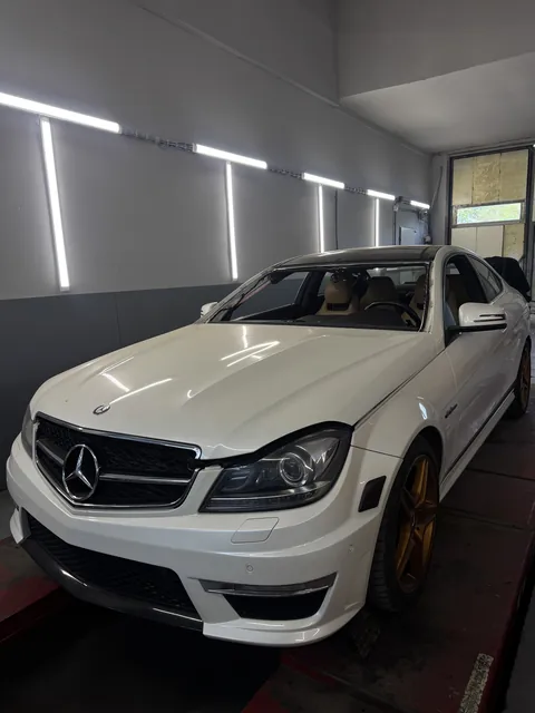 Bílý Mercedes v servisní dílně.