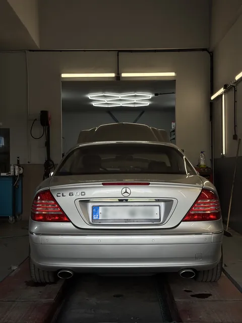 Zadní pohled na stříbrný Mercedes na servisní plošině.