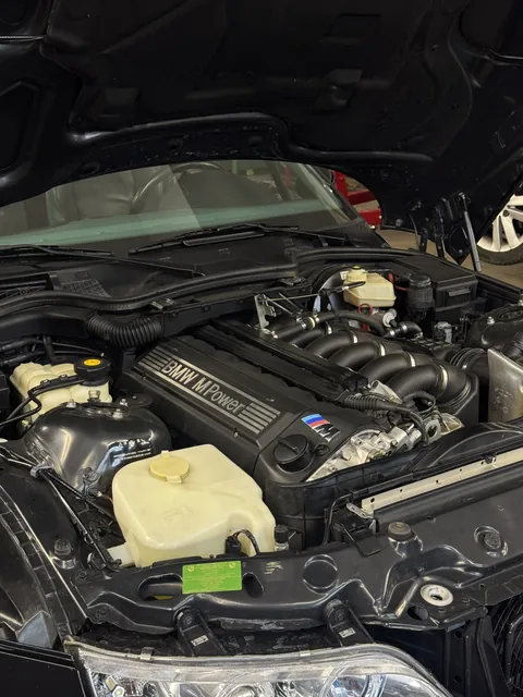 Detail motorového prostoru BMW s otevřenou kapotou.