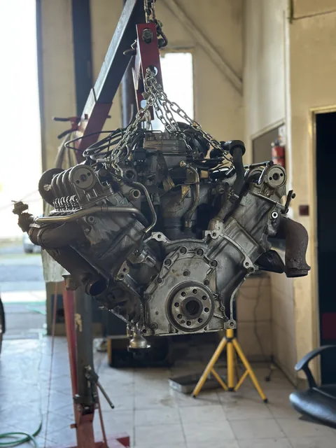 Motor zavěšený na dílenském jeřábu.