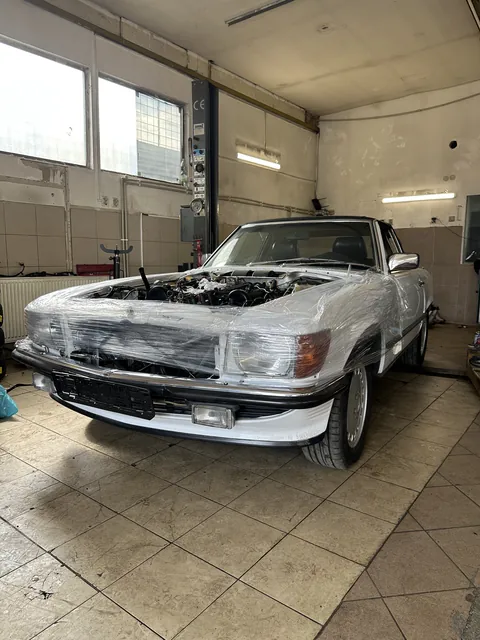 Starší Mercedes během opravy s chráněnou karoserií.
