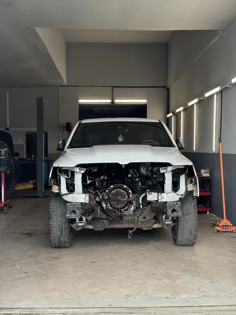 Vozidlo na zvedáku s demontovaným motorem a přední částí.