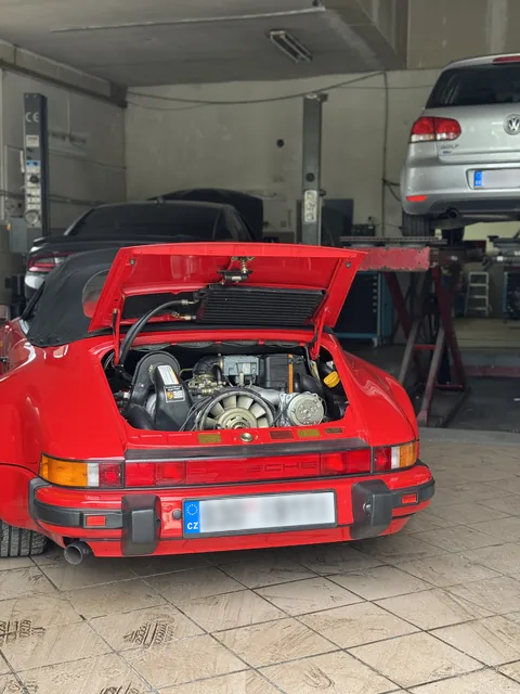 Červené Porsche s otevřeným motorovým prostorem.