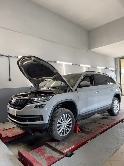 Škoda s otevřenou kapotou na servisní plošině.